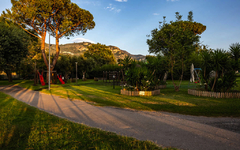 Gartenlandschaft im Sopramare Resort mit Bäumen und Spielplatz, Amalfiküste, Italien.