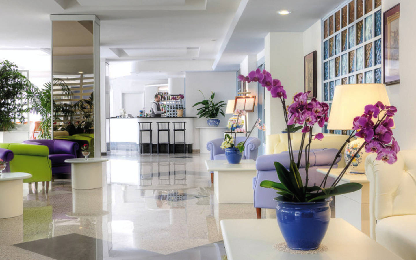 Moderner Hotel-Loungebereich mit Pflanzen und einladenden Sitzgelegenheiten.