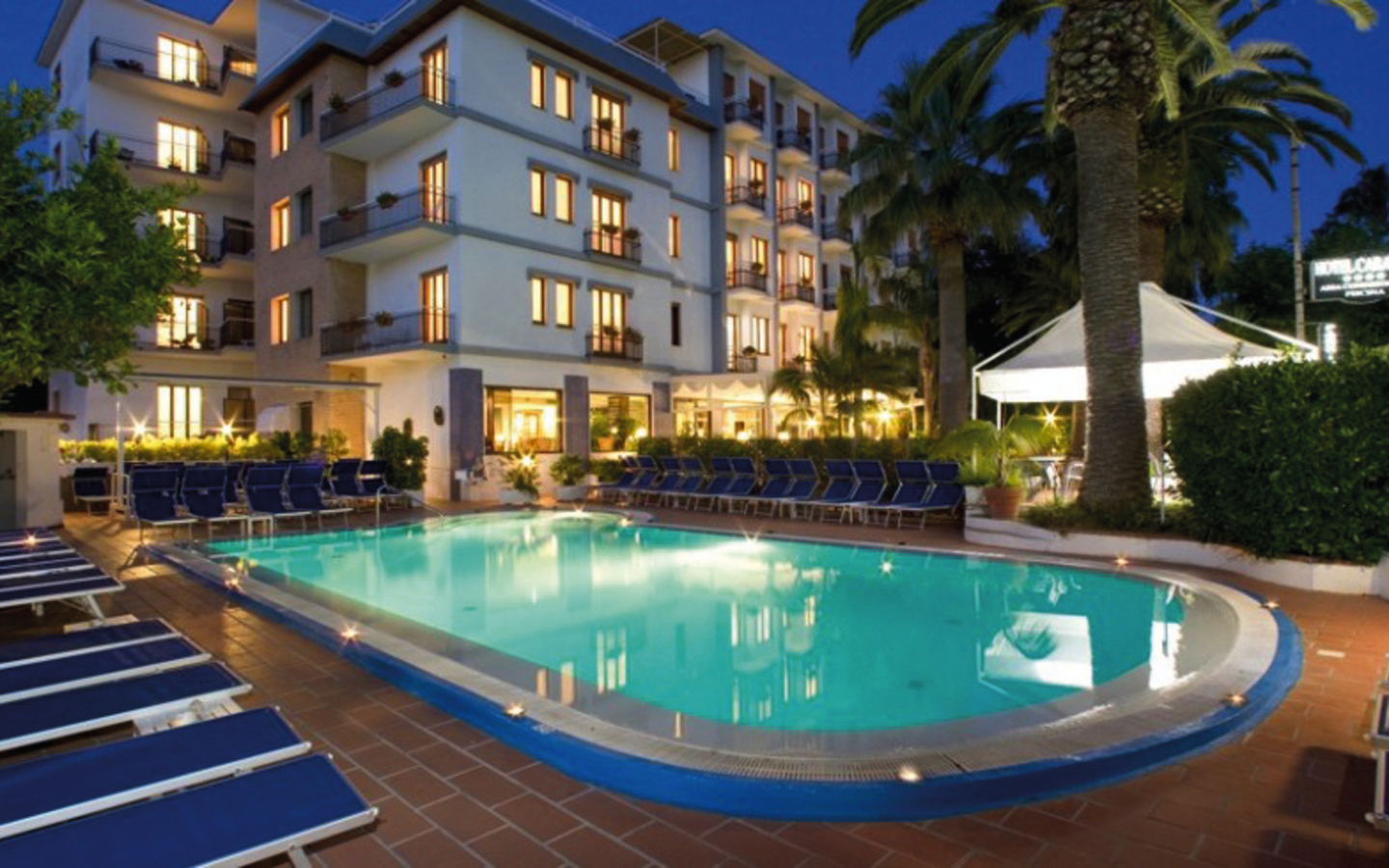 Hotel Caravel in Italien an der Amalfiküste bei Nacht mit beleuchtetem Pool und Liegestühlen