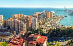 Stadtansicht von Málaga mit Stierkampfarena und Hafen im Hintergrund