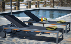 Zwei Liegestühle mit Getränken und Handtüchern am Pool eines Hotels.