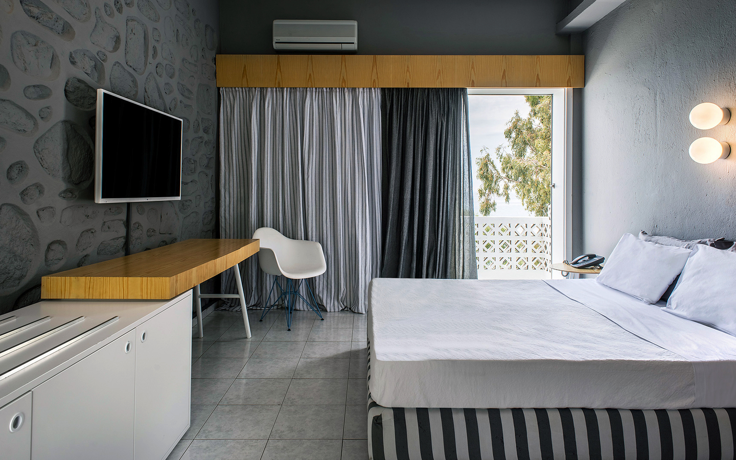 Moderne Hotelzimmer-Einrichtung mit Bett, Schreibtisch und Fernseher.