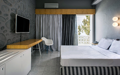 Moderne Hotelzimmer-Einrichtung mit Bett, Schreibtisch und Fernseher.
