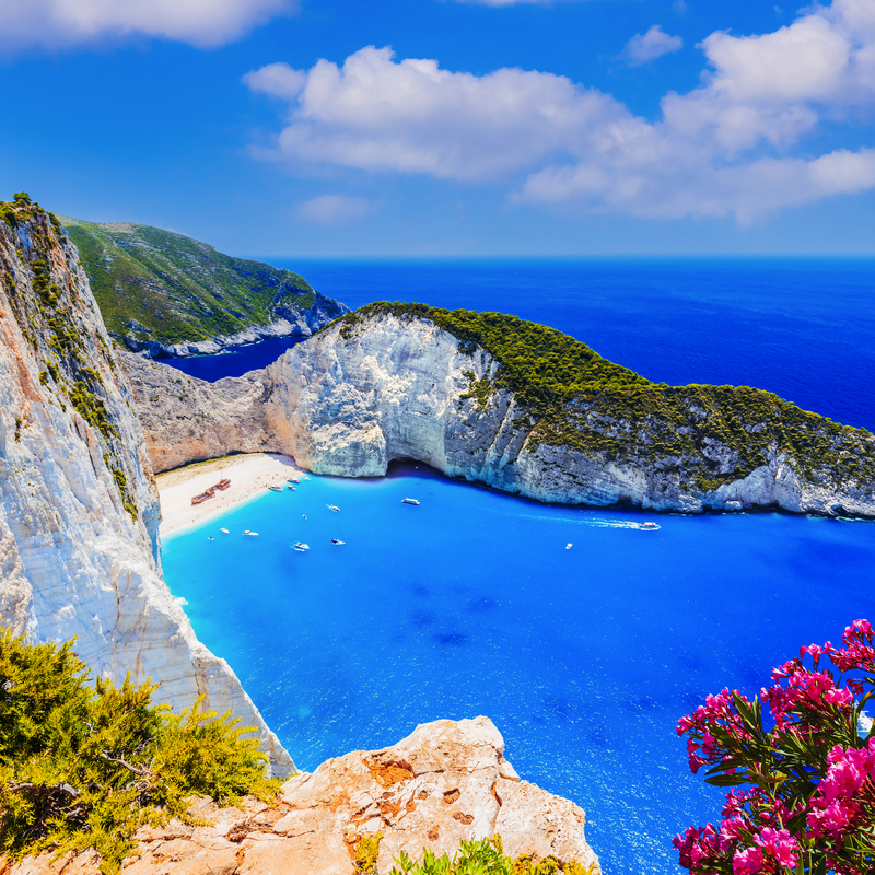 Navagio Beach mit Schiffswrack auf Zakynthos, umgeben von klarem, blauem Wasser und Klippen.