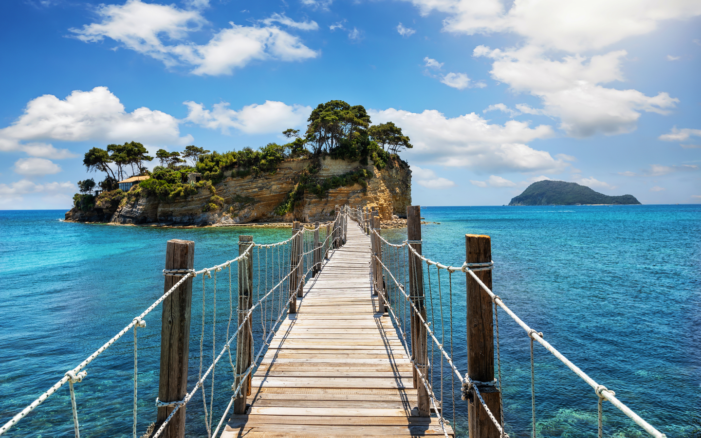 Brücke zu kleiner Insel mit Bäumen im blauen Meer, Griechenland, Zakynthos.