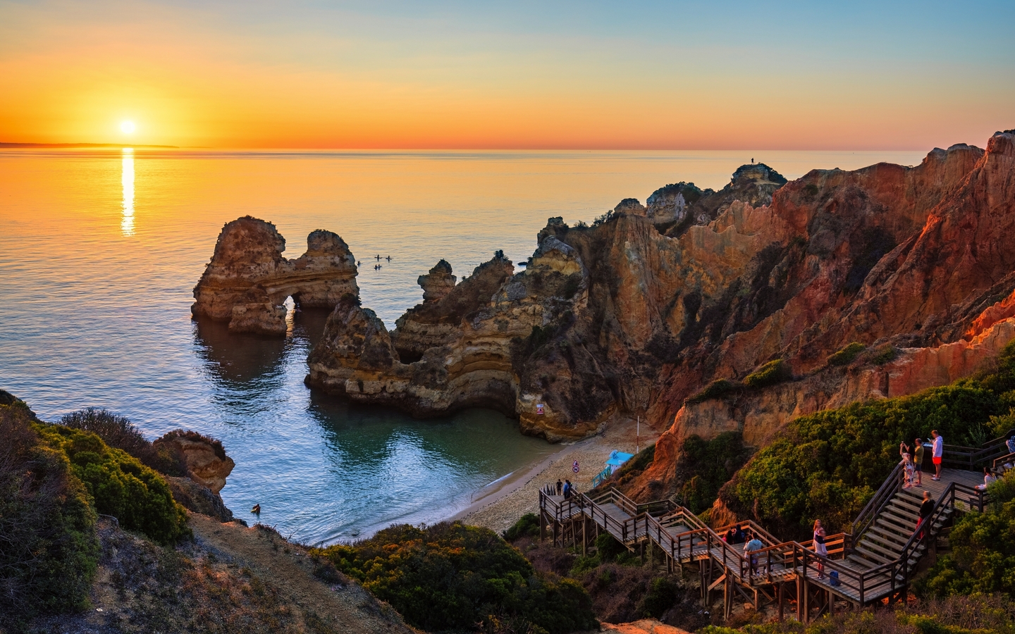 Klippen und Treppen am Camilo-Strand in Algarve bei Sonnenuntergang