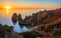Klippen und Treppen am Camilo-Strand in Algarve bei Sonnenuntergang