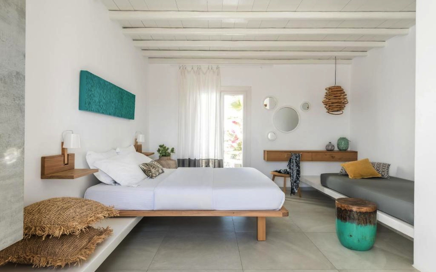 Deluxe Zimmer in einem Hotel auf Mykonos mit modernem Dekor und Doppelbett.