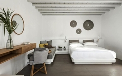 Deluxe-Zimmer in einem Hotel auf Mykonos mit modernem Dekor und Sitzbereich.
