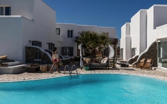 Außenansicht eines Hotels auf Mykonos mit Pool und weißen Gebäuden.