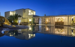 Hotel auf Mykonos mit Pool, beleuchtet bei Dämmerung.