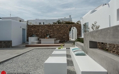 Moderne Hotelterrasse auf Mykonos mit weißen Gebäuden und minimalistischer Einrichtung.