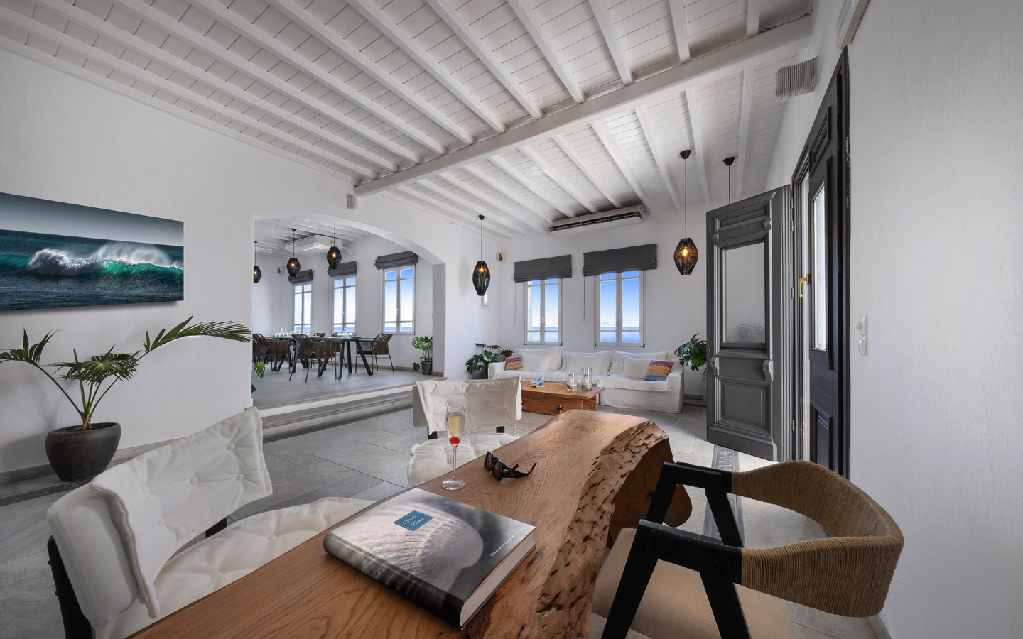 Moderner Hotelraum mit Holztisch, weißen Möbeln und Dekoration in Mykonos.
