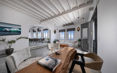 Moderner Hotelraum mit Holztisch, weißen Möbeln und Dekoration in Mykonos.