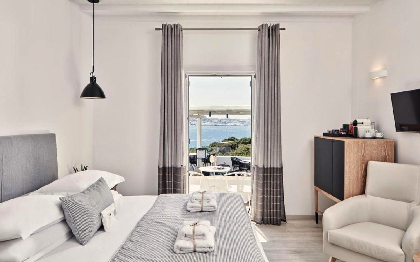 Helles Hotelzimmer mit Doppelbett und Meerblick auf Mykonos.