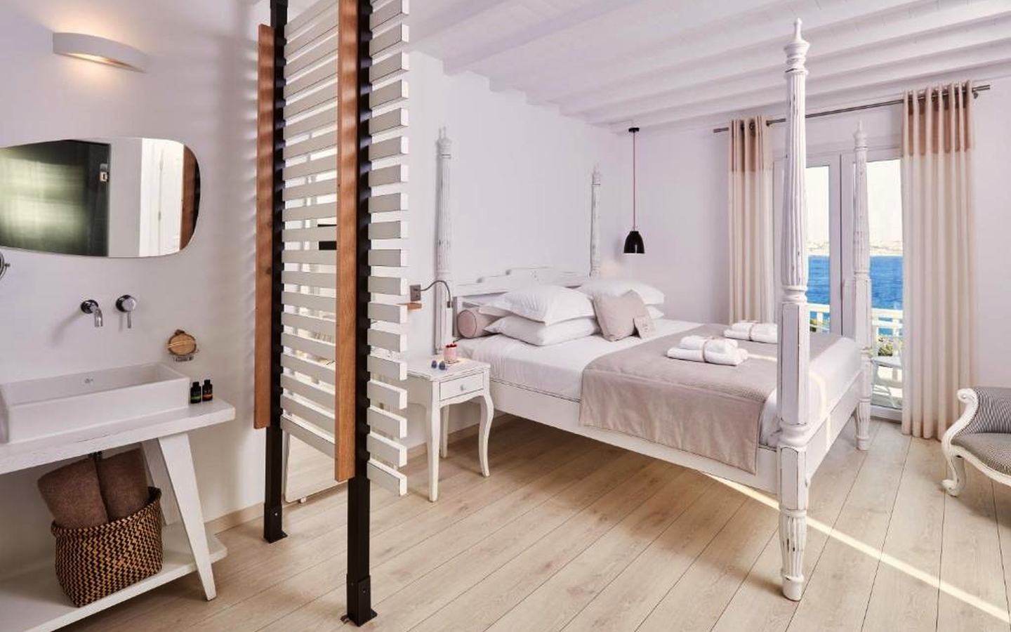 Helle Suite mit Himmelbett und Meerblick in modernem, minimalistischem Stil.