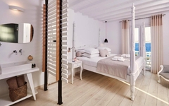 Helle Suite mit Himmelbett und Meerblick in modernem, minimalistischem Stil.