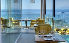 Restaurant mit Meerblick und gelben Sesseln in einem Hotel auf Mykonos
