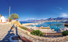 Hafen von Chersonissos auf Kreta mit Booten und hügeliger Landschaft im Hintergrund.