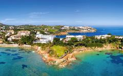 Küste von Agia Pelagia auf Kreta mit klarem blauem Meer und Häusern.