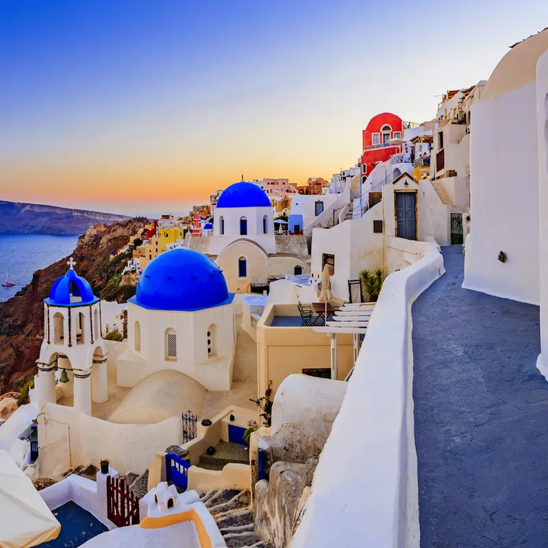 Weiß-blaue Häuser und Meerblick bei Sonnenuntergang auf Santorini, Griechenland.