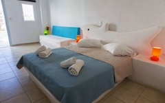 Doppelbett in hell eingerichtetem Hotelzimmer mit Kingsize-Bett und bunten Lichtern.