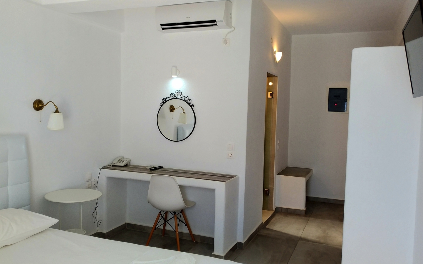 Modern eingerichtetes Hotelzimmer mit Schreibtisch, Stuhl und Spiegel.