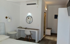 Modern eingerichtetes Hotelzimmer mit Schreibtisch, Stuhl und Spiegel.