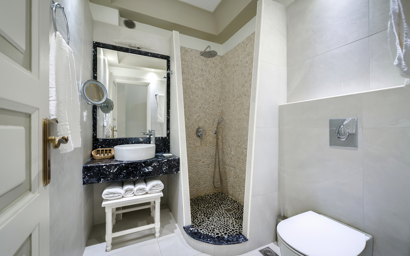 Modernes Hotelbadezimmer mit Dusche und Waschbecken in hellen Farben.