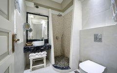 Modernes Hotelbadezimmer mit Dusche und Waschbecken in hellen Farben.