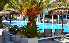 Poolbereich mit Liegestühlen und Sonnenschirmen im Hotel Zephyros auf Santorin.