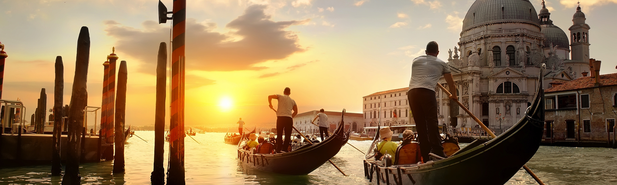 Gondeln fahren bei Sonnenuntergang vor Santa Maria della Salute in Venedig.