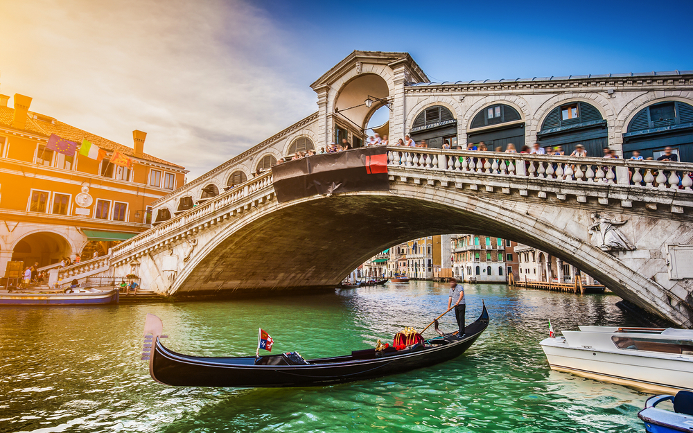 Gondel auf dem Wasser vor der Rialto-Brücke in Venedig bei Sonnenschein