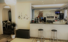Helle Hotelbar mit modernen Hockern und dekorativer Beleuchtung.
