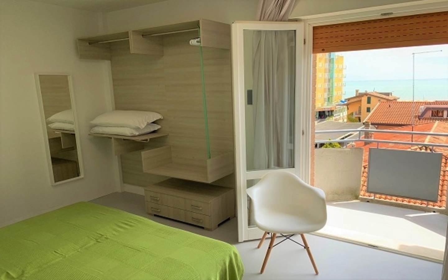 Hotelzimmer mit Bett, Balkon und Meerblick in Venedig, Italien.