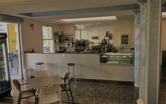 Innenraum eines Hotelcafés mit Stühlen, Tischen und einer Bar.