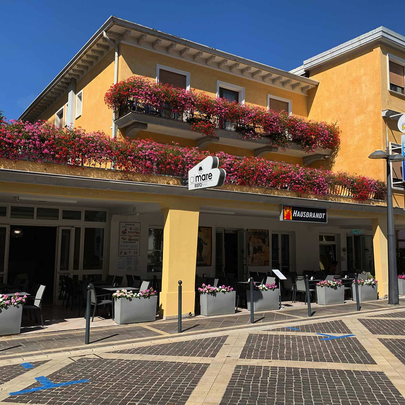Gelbes Hotelgebäude mit blühenden Balkonen in Venedig, Italien.