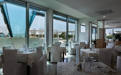Helles Restaurant mit gedeckten Tischen und Blick nach draußen.