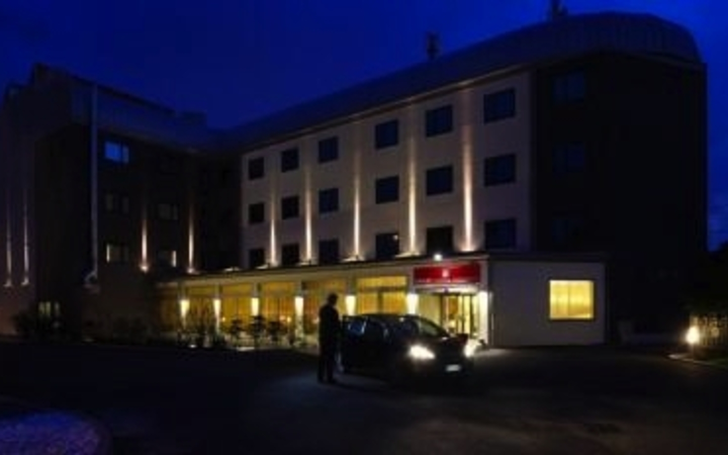 Außenansicht eines beleuchteten Hotels bei Nacht in Venedig.