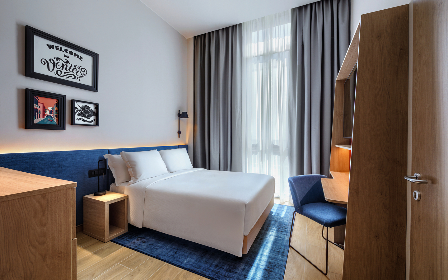 Doppelzimmer im Hampton by Hilton Venice mit modernem Design und großen Fenstern.