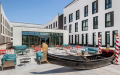 Terrasse des Hampton by Hilton Venice mit Sitzgelegenheiten und Dekogondel.