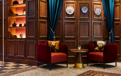 Rezeption im Hotel Indigo Venedig mit dekorativen Holzwänden und eleganten Sesseln.