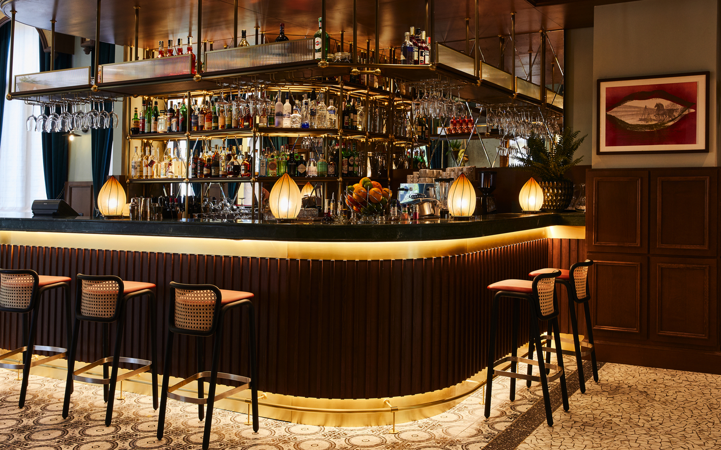 Elegant eingerichtete Hotelbar mit Hockern und beleuchtetem Tresen.