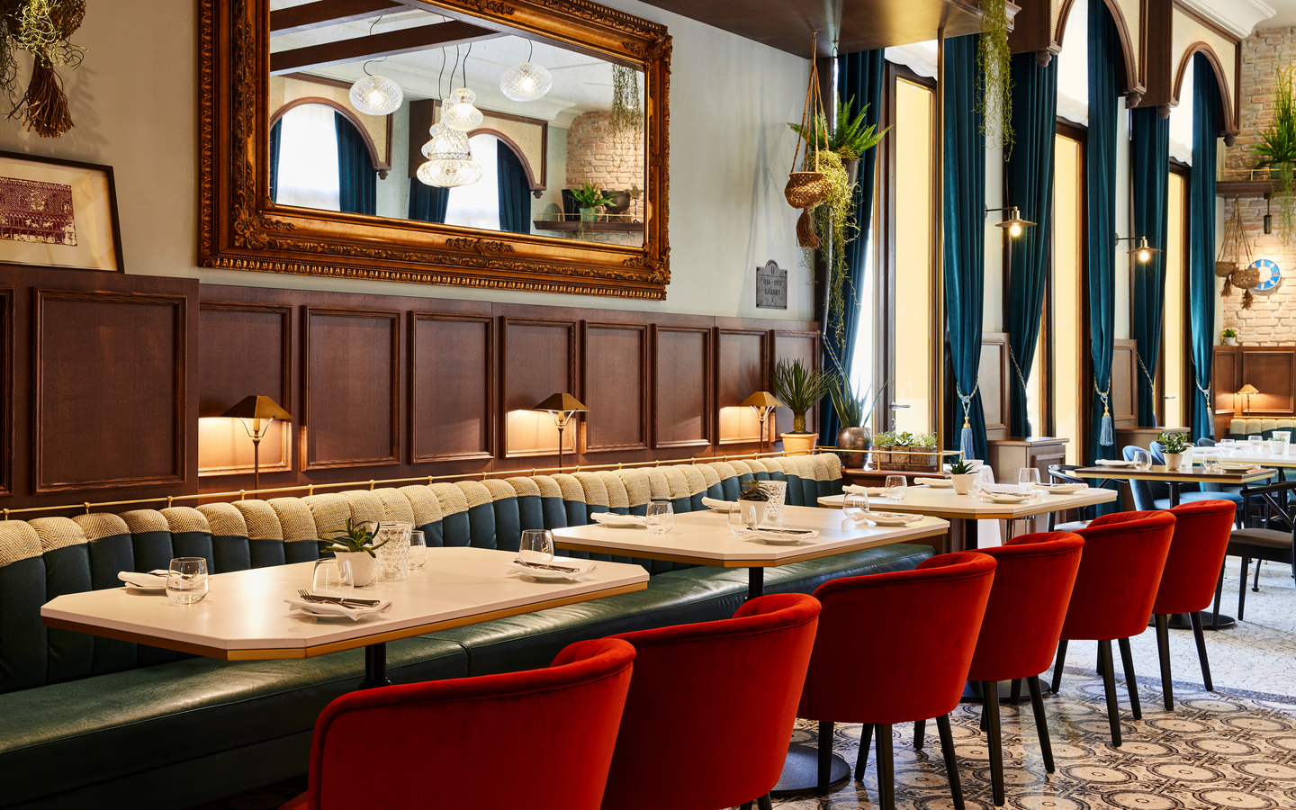 Elegantes Restaurant mit roten Stühlen und großen Spiegeln im Hotel Indigo Venedig.