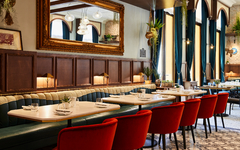 Elegantes Restaurant mit roten Stühlen und großen Spiegeln im Hotel Indigo Venedig.