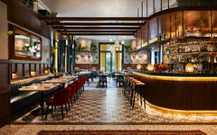 Innenraum eines stilvollen Restaurants mit Tischen und einer eleganten Bar im Hotel Indigo Venice.