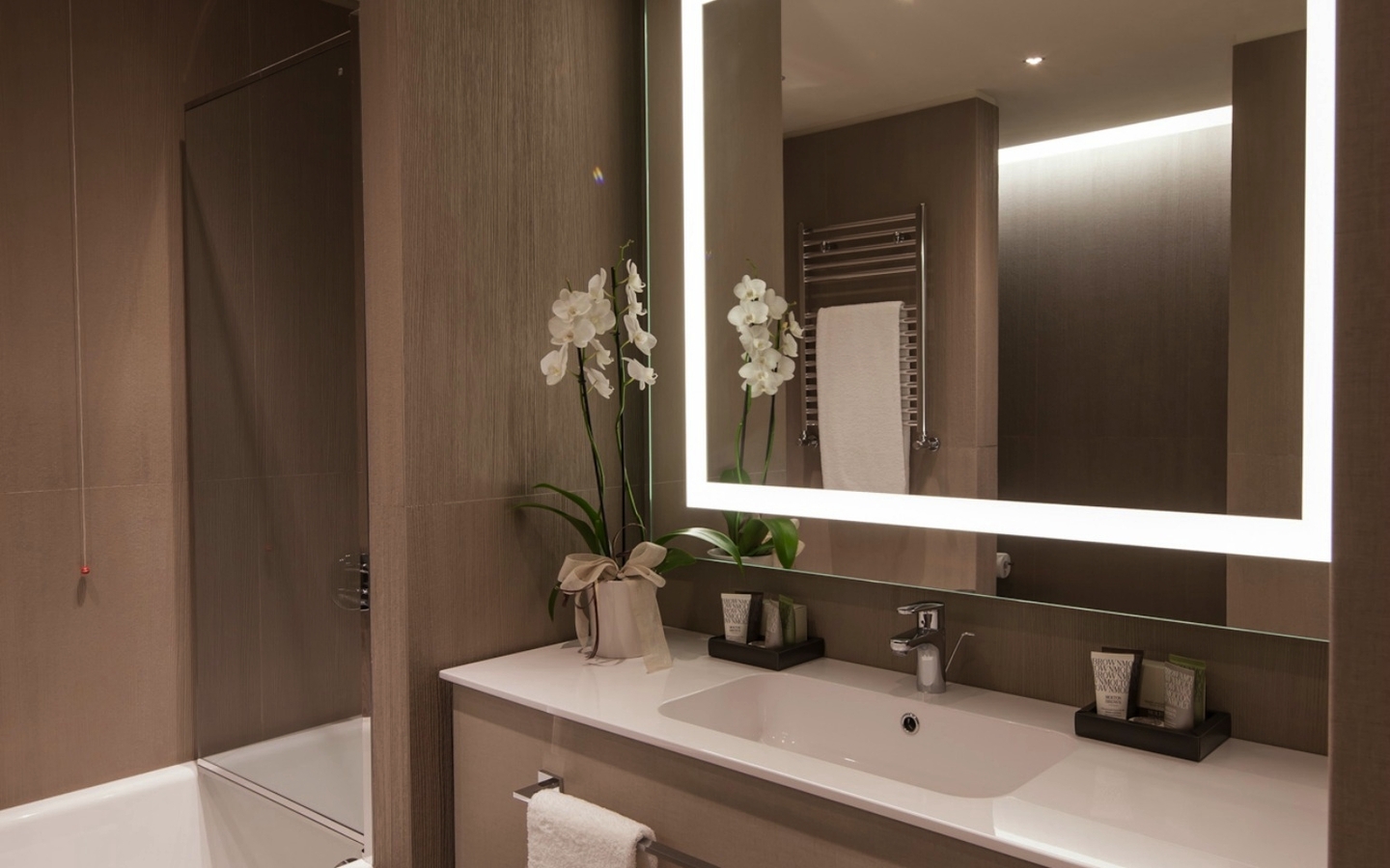 Modernes Badezimmer mit beleuchtetem Spiegel im Hyatt Centric Murano Venedig.