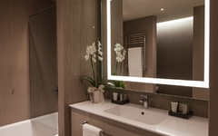 Modernes Badezimmer mit beleuchtetem Spiegel im Hyatt Centric Murano Venedig.