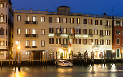 Hotel an einem beleuchteten Kanal in Venedig bei Nacht.
