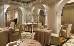 Elegantes Restaurant mit gedeckten Tischen und dekorativen Bögen im Hotel in Venedig.